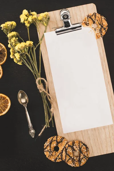 Blank paper on clipboard and cookies — Stock Photo