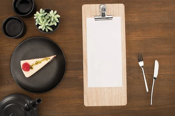 Sheet of paper on clipboard and tea set — Stock Photo