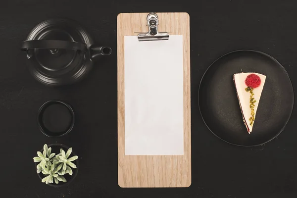 Sheet of paper on clipboard and tea set — Stock Photo