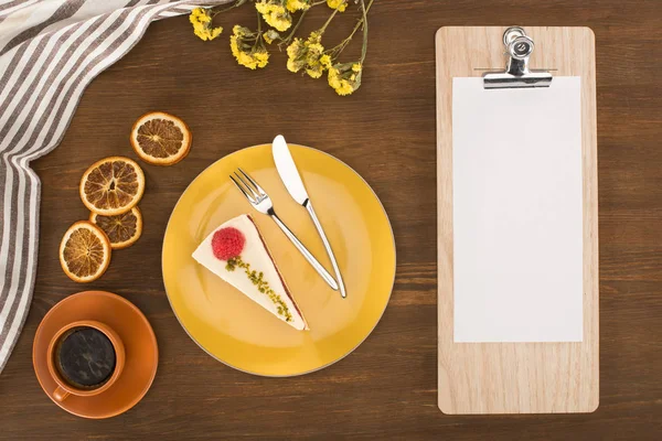 Sheet of paper on clipboard and dessert — Stock Photo