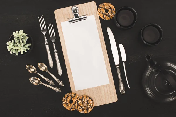 Blank paper on clipboard and cookies — Stock Photo