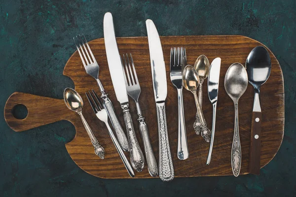 Cutting board with cutlery — Stock Photo