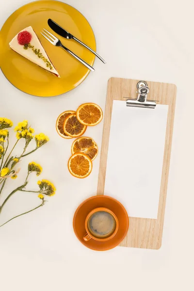 Feuille de papier sur presse-papiers et dessert — Photo de stock