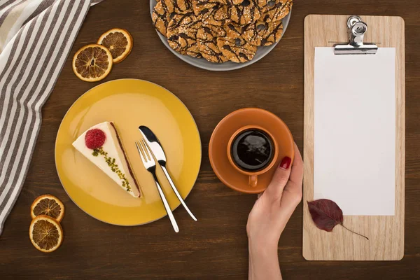 Hand with coffee and pastries — Stock Photo