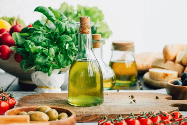 Бутылки оливкового масла с овощами — стоковое фото