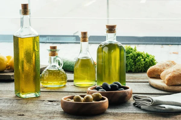 Бутылки оливкового масла с овощами — стоковое фото