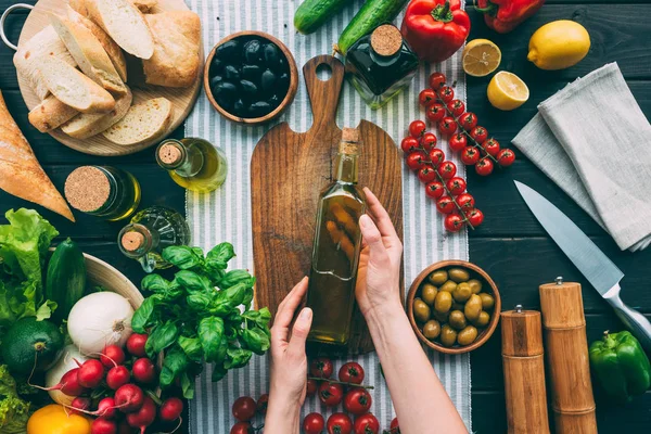 Hände halten Flasche mit Olivenöl — Stockfoto