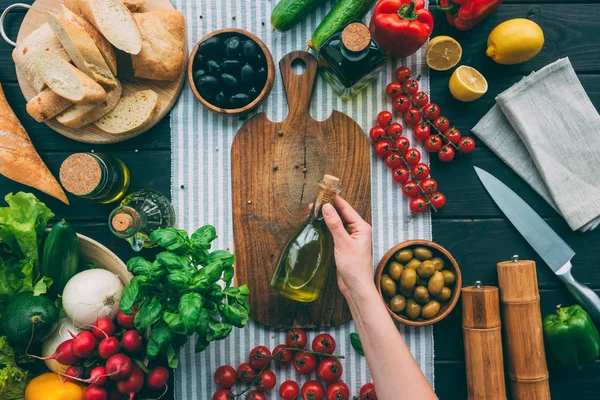 Manos sosteniendo la botella con aceite de oliva - foto de stock