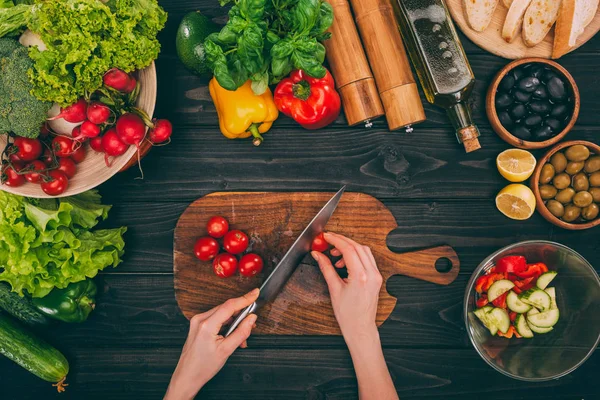 Les mains tranchant les tomates au couteau — Photo de stock