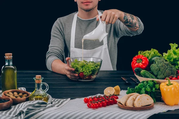 Hombre vierte aceite en tazón - foto de stock