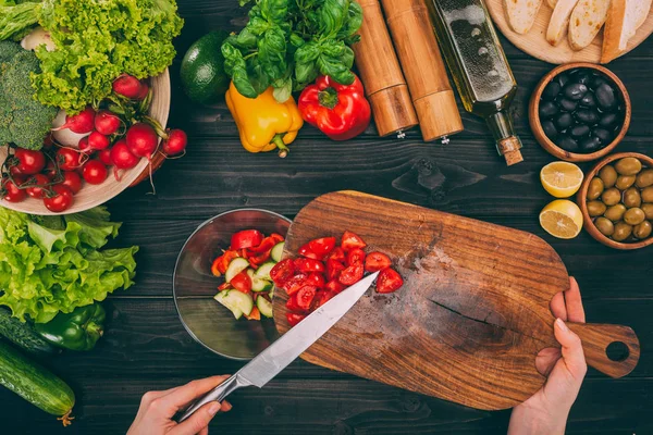 Mani che tengono tagliere con coltello — Foto stock