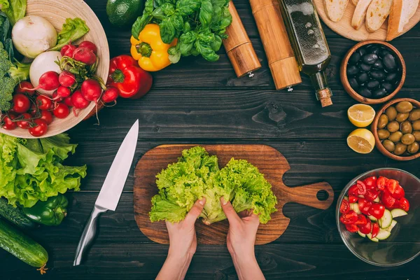 Hands with salad leaves and vegetables — Stock Photo
