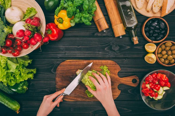 Mãos cortando salada — Fotografia de Stock