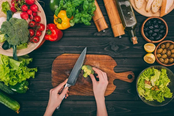 Manos con cuchillo y verduras - foto de stock