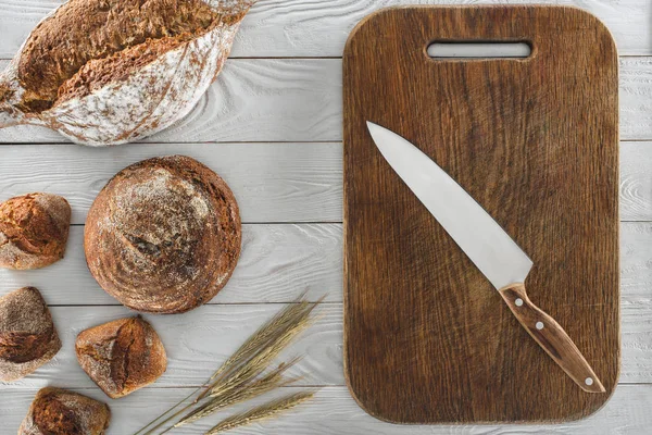 Pain et planche à découper avec couteau — Photo de stock