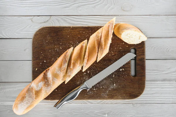 Baguette en rodajas y cuchillo - foto de stock