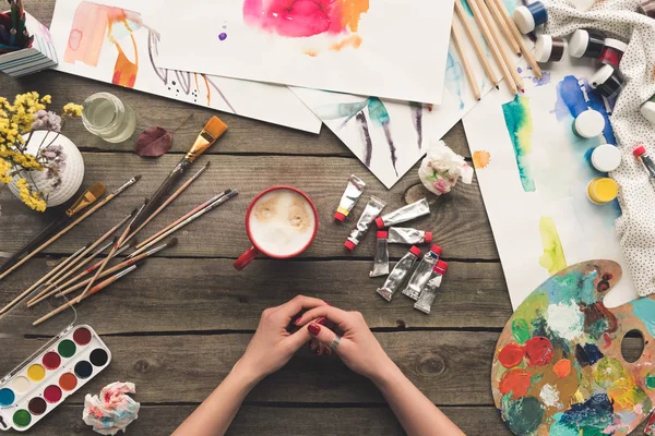 Painter sitting at working table — Stock Photo