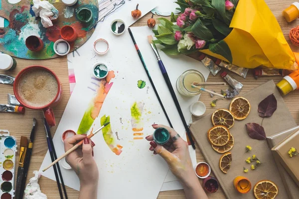 Designer holding brush and poster paint — Stock Photo