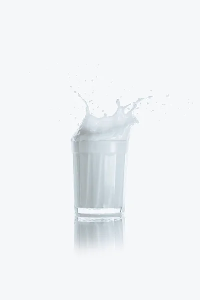 Salpicadura de leche en vaso - foto de stock