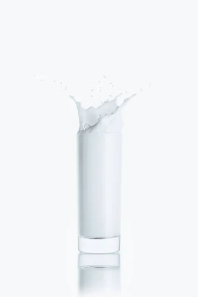 Salpicadura de leche en vaso - foto de stock