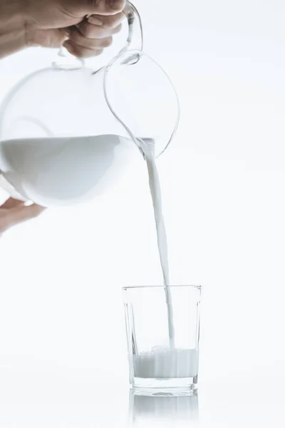 Pessoa que vaza leite do jarro — Fotografia de Stock