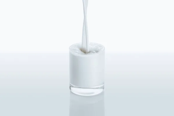 Milch ins Glas gießen — Stockfoto