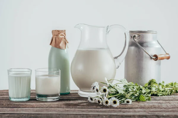 Jarros, garrafa e copos de leite fresco — Fotografia de Stock