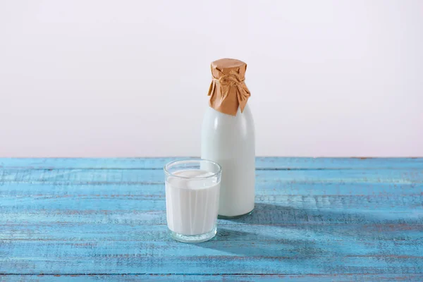 Botella y vaso de leche fresca - foto de stock