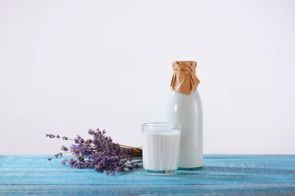 Botella y vaso de leche con lavanda - foto de stock