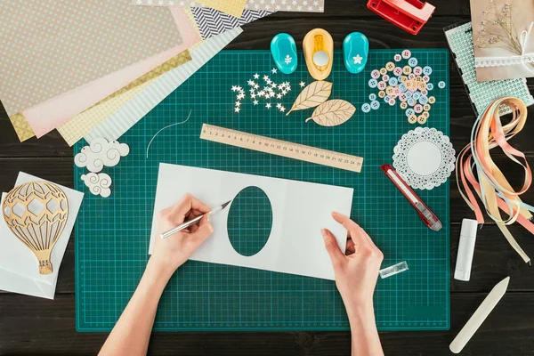 Cropped image of designer making scrapbooking decoration for postcard — Stock Photo
