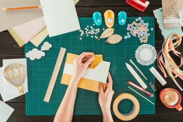 Cropped image of designer taking off adhesive tape from sheet of paper — Stock Photo