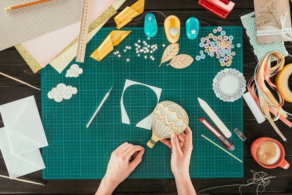 Cropped image of designer holding cut decorative balloon in hand — Stock Photo