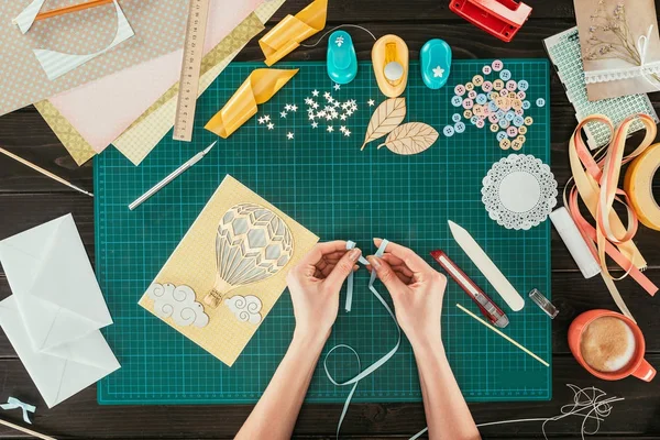 Cropped image of designer making bow with ribbon — Stock Photo