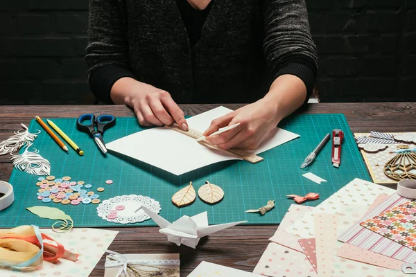 Cropped image of designer cutting paper for scrapbooking greeting postcards — Stock Photo