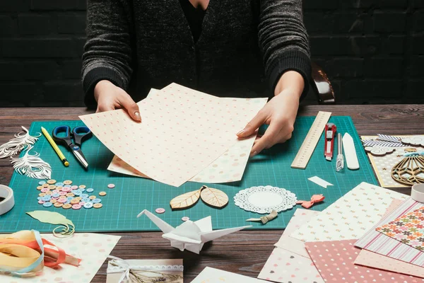 Cropped image of designer choosing paper for scrapbooking postcard — Stock Photo