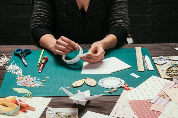 Abgeschnittenes Bild eines Designers, der ein Stück Klebeband nimmt — Stockfoto