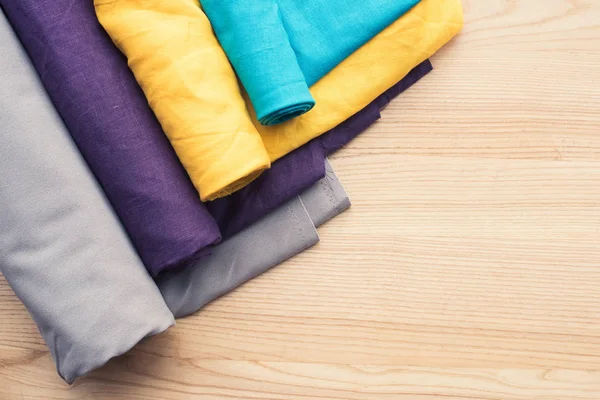 Vista superior de mesa de madera con rollos de tela — Stock Photo