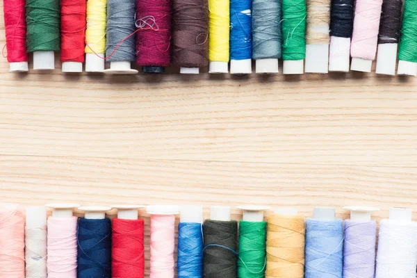 Cadre coloré de coutures sur fond en bois avec espace de copie — Photo de stock