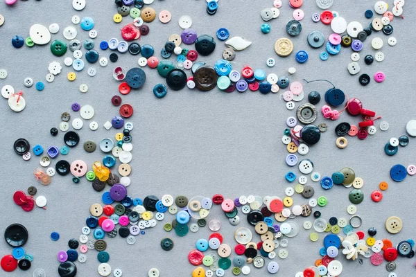 Top view of colorful buttons frame on grey cloth background — Stock Photo