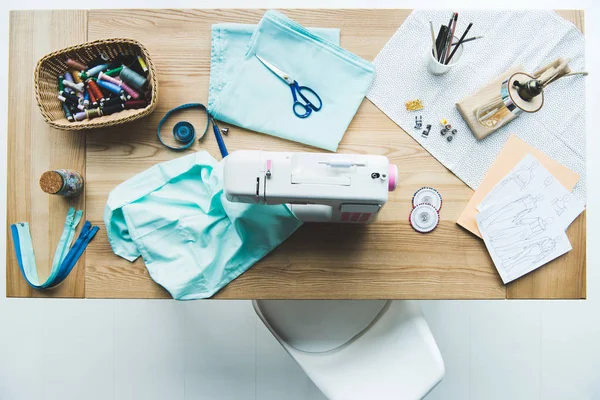 Vue de dessus du lieu de travail de couturière avec tissu, machine à coudre, courants d'air et coutures — Photo de stock