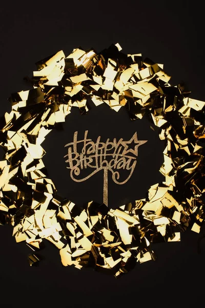 Top view of happy birthday sign and golden confetti isolated on black — Stock Photo