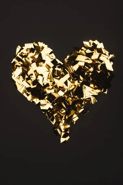Top view of golden confetti arranged in heart shape isolated on black — Stock Photo