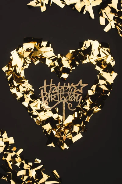 Top view of happy birthday sign and golden confetti isolated on black — Stock Photo