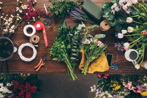 Vista superior de las partes de ramo y herramientas de decoración en la mesa - foto de stock