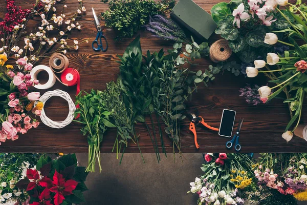 Top view of different twigs with green leaves on florist table — Stock Photo