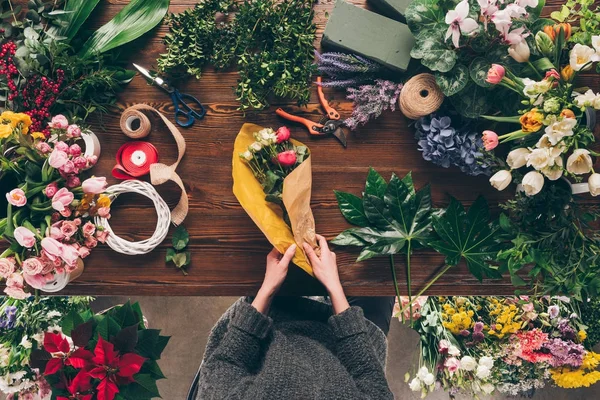 Imagem cortada de buquê de embrulho florista em papel de embalagem amarelo — Fotografia de Stock