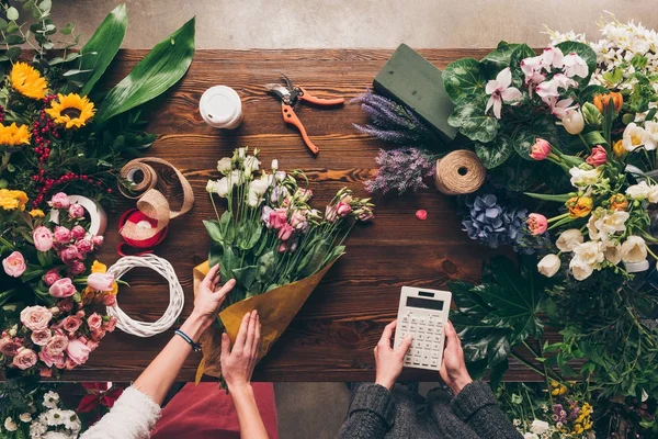 Imagen recortada del ramo de envoltura de floristería en papel de paquete - foto de stock