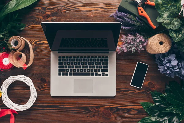 Top view of laptop and smartphone on florist working table — Stock Photo