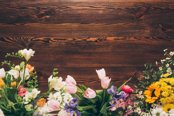 Vue de dessus de différentes fleurs colorées sur la table dans le magasin de fleurs — Photo de stock