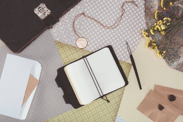 Top view of opened notebook with envelopes over pack paper background — Stock Photo